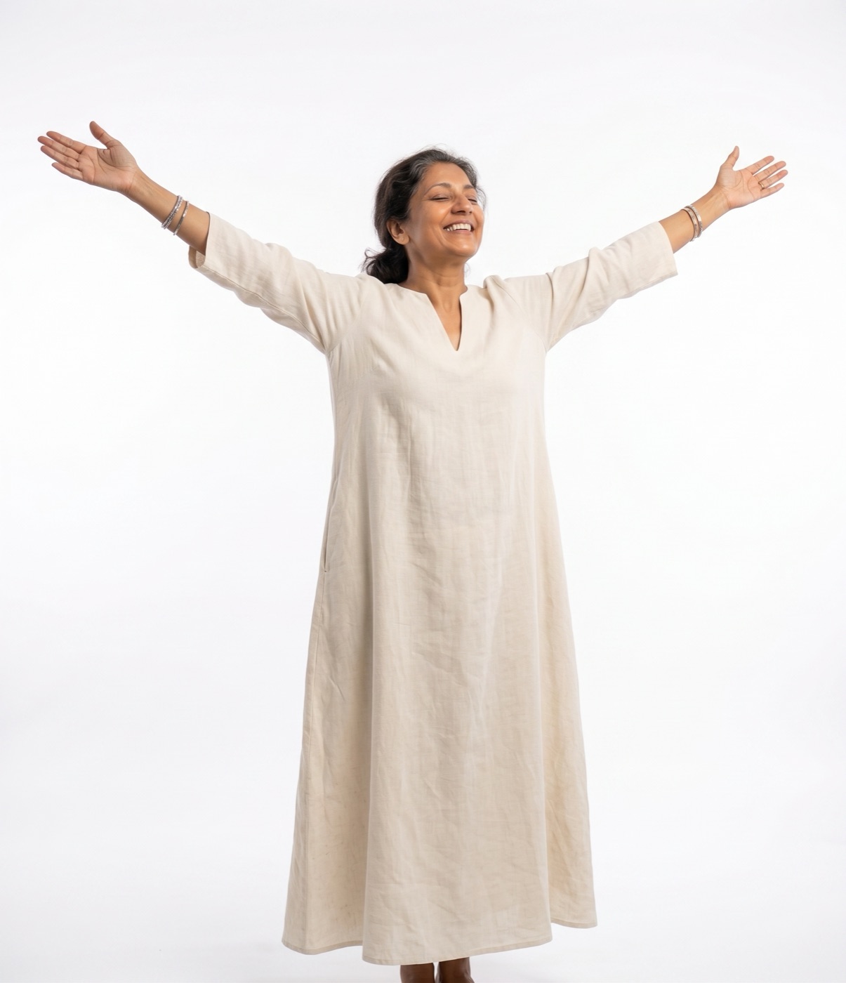 Woman smiling with arms open wide at sunset, free of pain